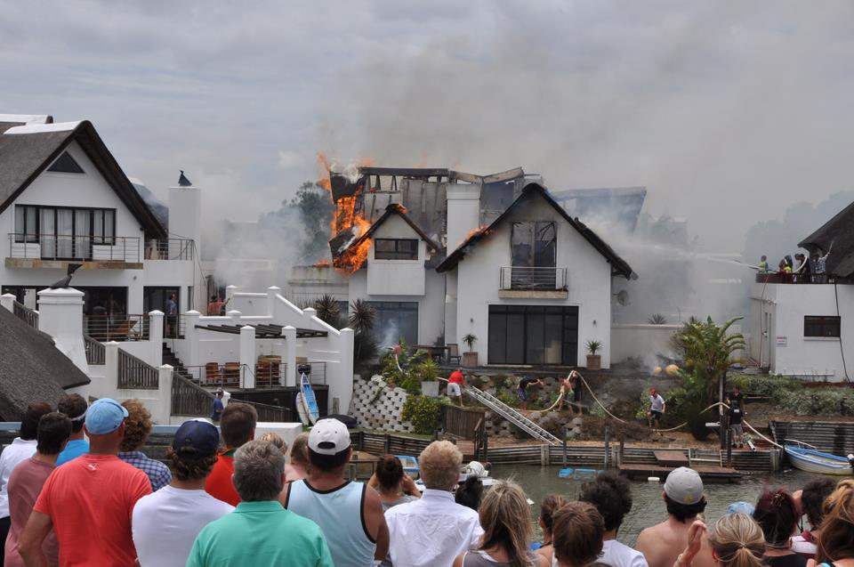 Crowd watches the cnal house burning at lunch time today. Photo: Sharon Welman