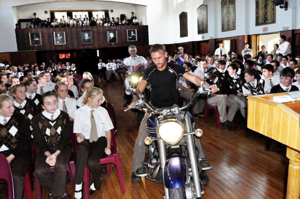 Jason Hartman and Dave Estment making an entrance on their bikes into the School Hall, as part of the Rock ‘n ride 4 Rhino project. 